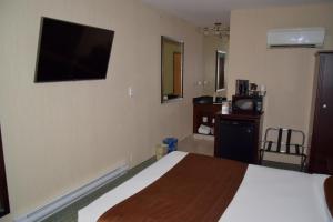 a hotel room with a television and a bed at Coast Lethbridge Hotel & Conference Centre in Lethbridge