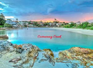 a view of a beach with rocks in the water at WARR4C - Home Away in Myola