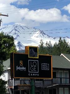 una señal frente a una montaña cubierta de nieve en LOGE Mt. Shasta, en Mount Shasta