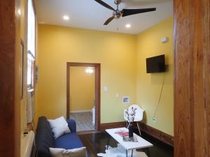 a living room with a blue couch and a ceiling fan at Historic Modern Uptown Home ll in New Orleans