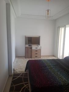 a bedroom with a bed and a dresser and a television at ola blanca 2 in Casablanca