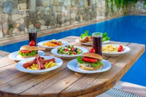 a wooden table with plates of food and drinks at Kabasakal Otel in Çeşme