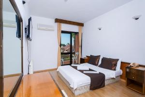 a bedroom with a bed and a flat screen tv at Kabasakal Otel in Çeşme