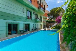 a swimming pool in front of a building at Kabasakal Otel in Çeşme