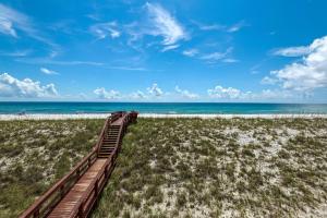 a wooden pathway to the beach with the ocean in the background at Sea Oats Condo Unit #202 in Navarre