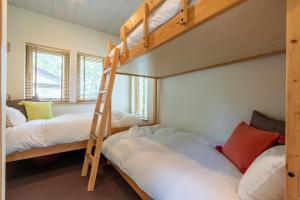 a bedroom with two bunk beds and a ladder at Tsukinoki in Niseko