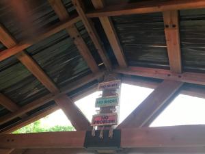 a wooden roof with four signs hanging from it at Ed & Rosie's Place in Black Mountain