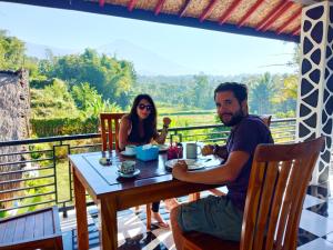 a man and a woman sitting at a table at Aryasuta Bungalow in Tetebatu