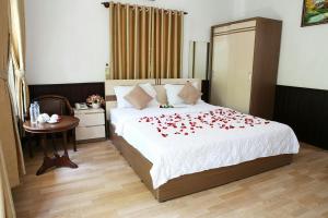 Un dormitorio con una cama con rosas rojas. en Huynh Gia Bungalow, en Phu Quoc