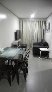 a living room with a table and chairs and a couch at Baguio Central Apartment by Goshenland in Baguio