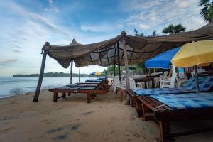 een groep stoelen en parasols op een strand bij The Surf Access Guest House in Arugam Bay