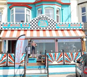 a man riding a skateboard in front of a music bar at Charlton Aparthotel in Blackpool