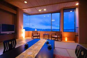 a room with a table and chairs and a large window at Kesennuma Plaza Hotel in Kesennuma