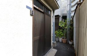 uma entrada para um edifício com plantas em vasos em Hakko Ichiu em Osaka