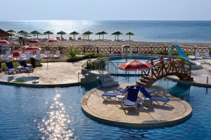 a swimming pool with chairs and umbrellas on a beach at Hotel Gergana - Ultra All Inclusive in Albena