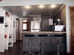 a kitchen with a counter with bar stools and appliances at Casa Indómita in Las Trancas