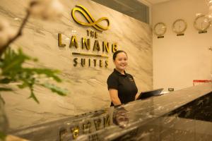 a woman standing in front of a counter with a laptop at The Lanang Suites in Davao City