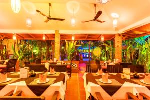 ein Restaurant mit Tischen, Stühlen und Pflanzen in der Unterkunft La Niche D'angkor Boutique Hotel in Siem Reap