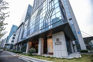 a building in the city with tall buildings at SSAW Boutique Hotel Ningbo CBD in Ningbo