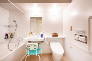 a white bathroom with a toilet and a sink at karaksa hotel TOKYO STATION in Tokyo