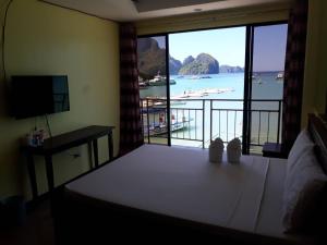 a bedroom with a bed and a view of a beach at Aqua Travel Lodge in El Nido