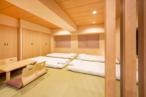 a room with four beds and a table in it at karaksa hotel TOKYO STATION in Tokyo