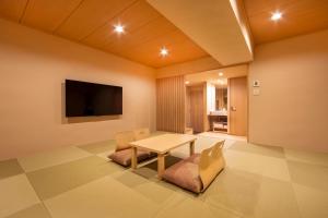 a living room with a table and chairs and a television at karaksa hotel TOKYO STATION in Tokyo