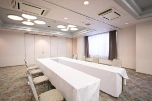 a conference room with a large white table and chairs at Kesennuma Plaza Hotel in Kesennuma