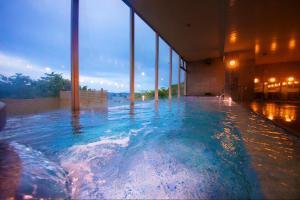 a large swimming pool with blue water in a building at Kesennuma Plaza Hotel in Kesennuma