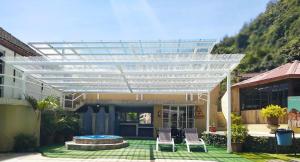 a pergola on a house with two chairs and a pool at Monte Selva Spa Termal in Baños