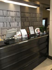 a counter in a library with books on the wall at Citadines Central Shinjuku Tokyo in Tokyo
