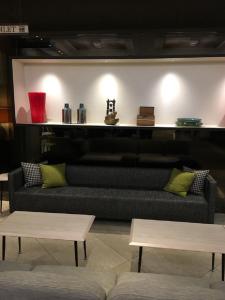 a living room with a black couch and two tables at Citadines Central Shinjuku Tokyo in Tokyo