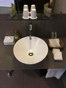 a white sink in a bathroom with towels on a counter at Citadines Central Shinjuku Tokyo in Tokyo