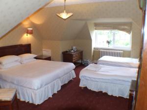 a hotel room with two beds and two lamps at Tayside Hotel in Stanley