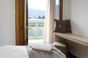 een slaapkamer met een bed en een raam met uitzicht bij Hotel Raffl in Bolzano