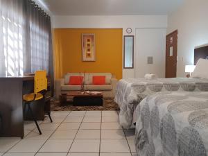 Habitación de hotel con 2 camas y sofá en B & A Suites Inn Hotel - Quarto Luxo Premium, en Anápolis