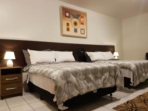 a bedroom with a large bed and a night stand at B & A Suites Inn Hotel - Quarto Luxo Premium in Anápolis
