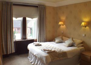 a bedroom with a large bed and a large window at Tayside Hotel in Stanley