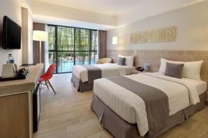 Postel nebo postele na pokoji v ubytování Hotel NEO+ Kuta Legian by ASTON