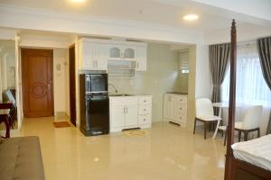 a kitchen with white cabinets and a black refrigerator at Homestay coco in Vung Tau