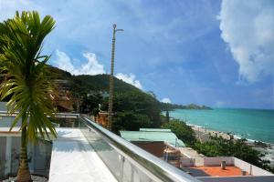 a view of the ocean from a balcony with a palm tree at Homestay coco in Vung Tau