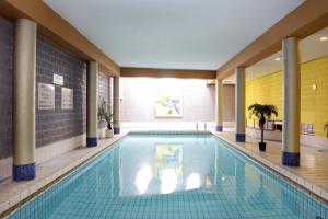 a large swimming pool in a building at Amr&acirc;th Grand Hotel de l&rsquo;Empereur in Maastricht