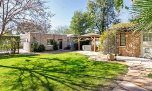 une arrière-cour avec une maison en briques et une cour en herbe dans l'établissement Best Little Guesthouse in Melrose! New Listing!, à Phoenix