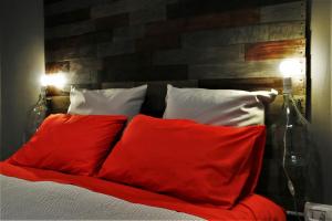uma cama com almofadas vermelhas e brancas em La Cornice em Nápoles