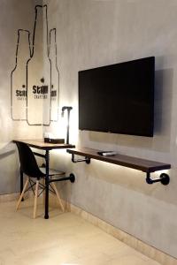 a desk with a chair and a television on a wall at Stark Boutique Hotel and Spa in Kuta