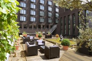 un patio con sillas y plantas frente a un edificio en Amrâth Grand Hotel de l’Empereur, en Maastricht