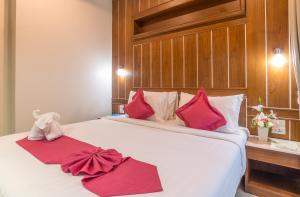 a bedroom with a large white bed with red pillows at The Scene Cliff View Villas in Ao Nang Beach