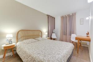 een slaapkamer met een groot bed en een bureau bij Votre adresse de charme centre historique de Béziers in Béziers