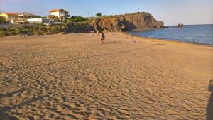 une personne se promenant sur une plage de sable près de l'eau dans l'établissement PORT RAPHAEL, au Cap d'Agde
