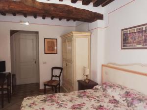 1 dormitorio con 1 cama y 1 silla en B&B Alle Due Porte, en Siena